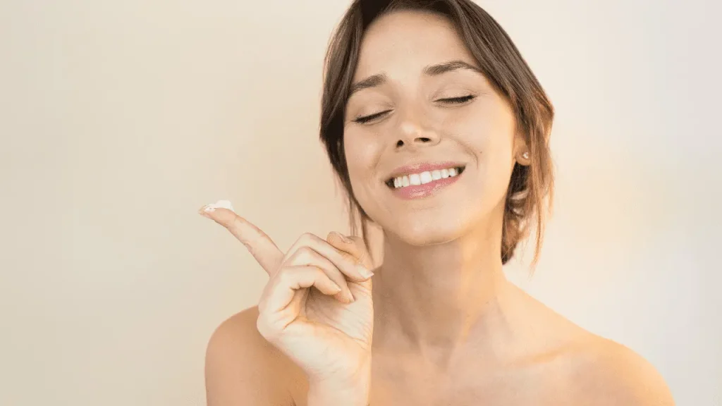 Lady applying cream on her face. 