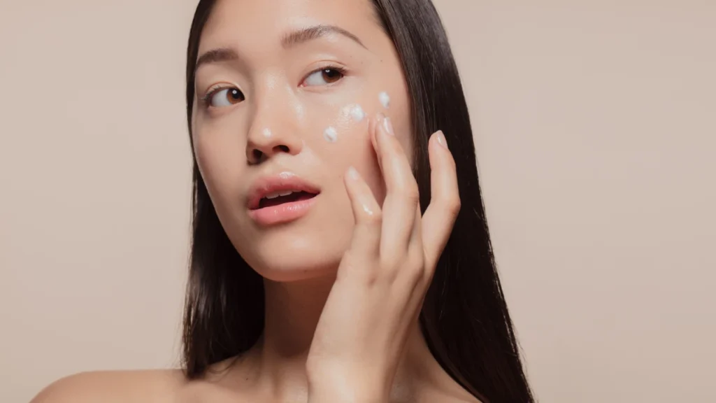 Girl applying dear brightly cream on her face 